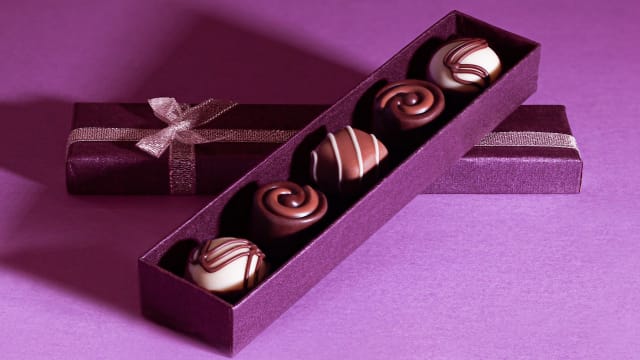 Valentine's Day chocolate in a box on a purple background