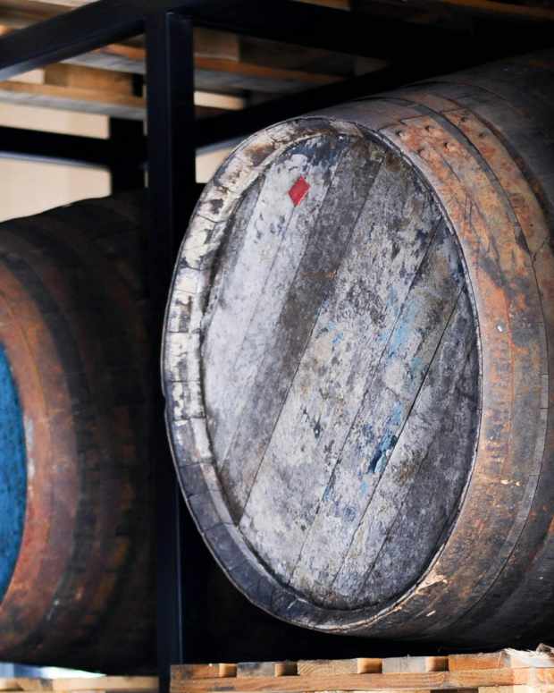 Three whiskey barrels on a shelf.