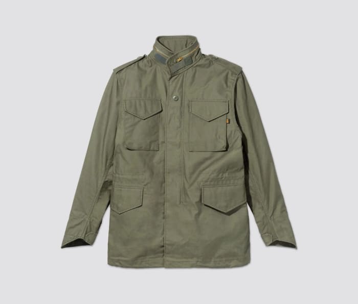 Green Alpha Industries M-65 Field Jacket on a grey background.