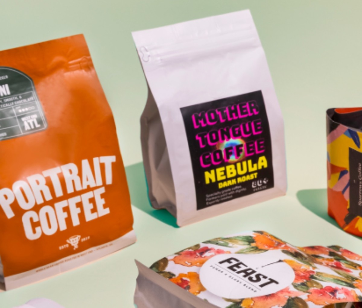 Different bags of coffee from a subscription service on a light green background.