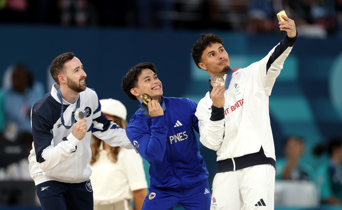 PARIS, FRANCE - AUGUST 03: (L-R) Silver medalist Artem Dolgopyat of Team Israel, Gold medalist Carlos Edriel Yulo of Team Philippines and Bronze medalist Jake Jarman of Team Great Britain pose for a selfie on the podium during the medal ceremony for the Artistic Gymnastics Men's Floor Exercise Final on day eight of the Olympic Games Paris 2024 at Bercy Arena on August 03, 2024 in Paris, France. (Photo by Julian Finney/Getty Images)