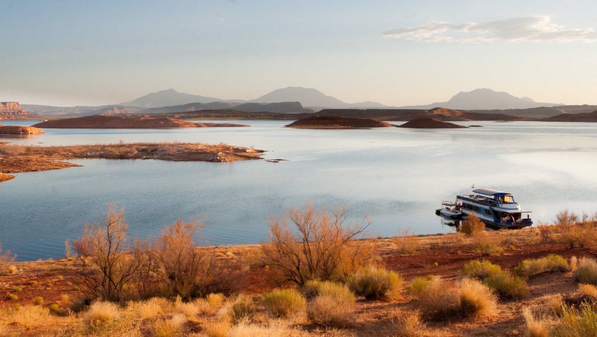 Houseboat Beautiful desert sunrise scene with houseboat at Lake Powell in Glen Canyon National Recreation