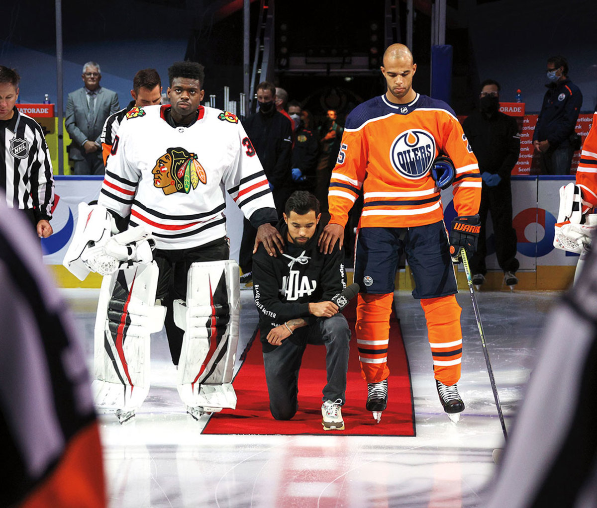 Between Blackhawks goalie Malcolm Subban and Oilers defenseman Darnell Nurse, Dumba kneels for the national anthem after his Aug. 1 playoffs speech.