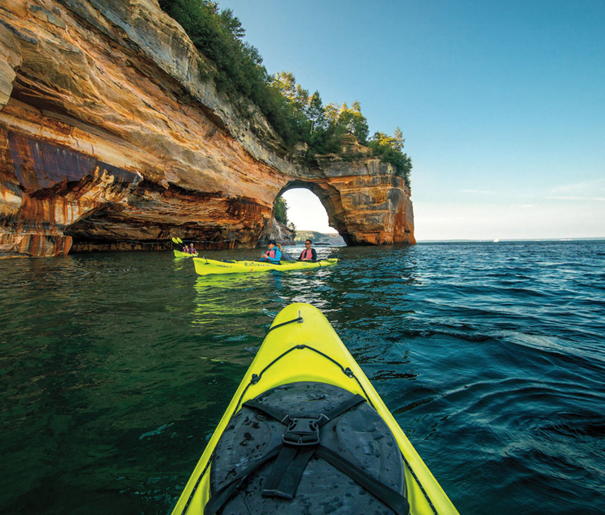 Two bright yellow kayaks near sea caves