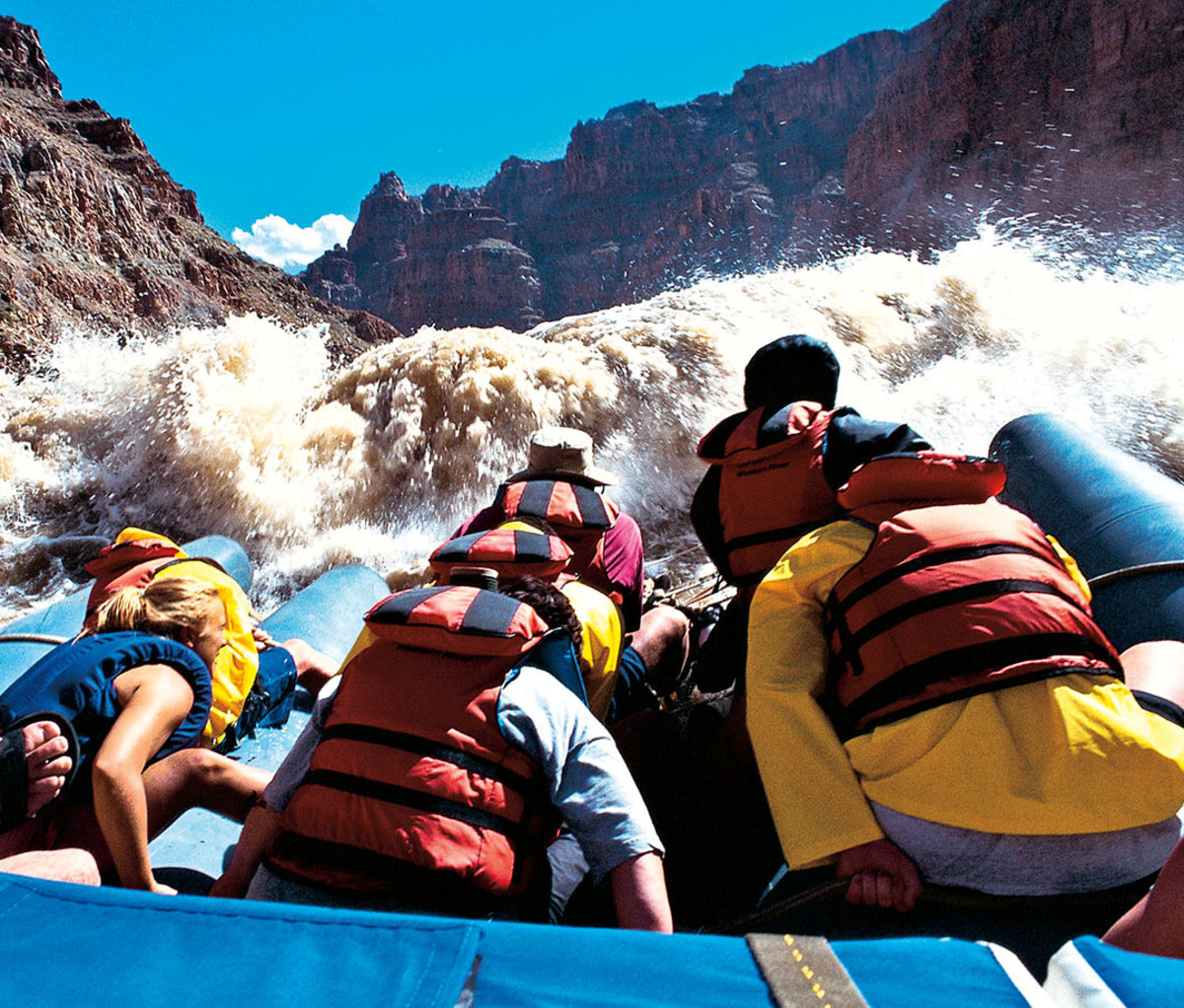 Men and women whitewater rafting 