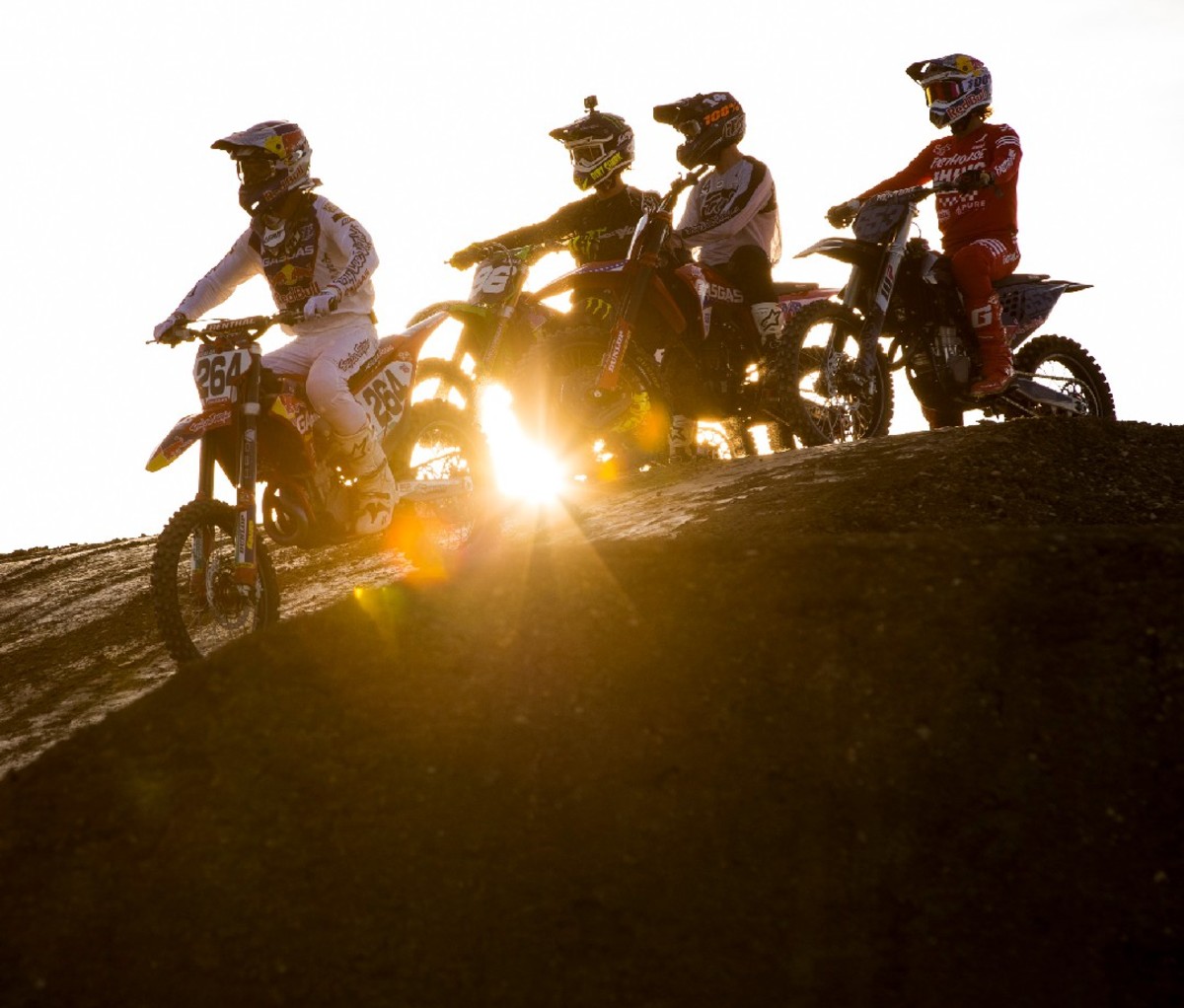Motocross riders with sun behind them