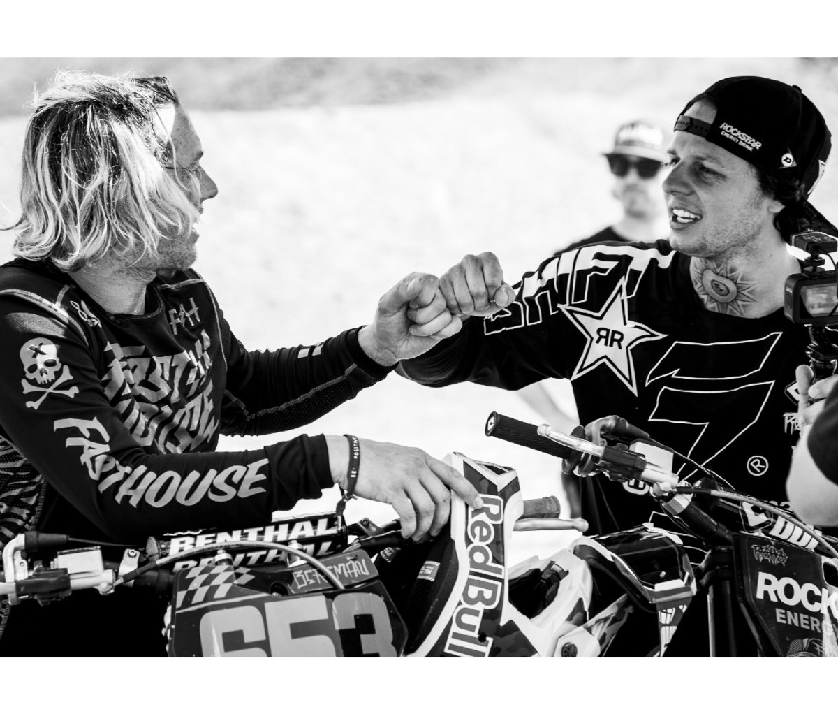 Two male motocross racers fist bump