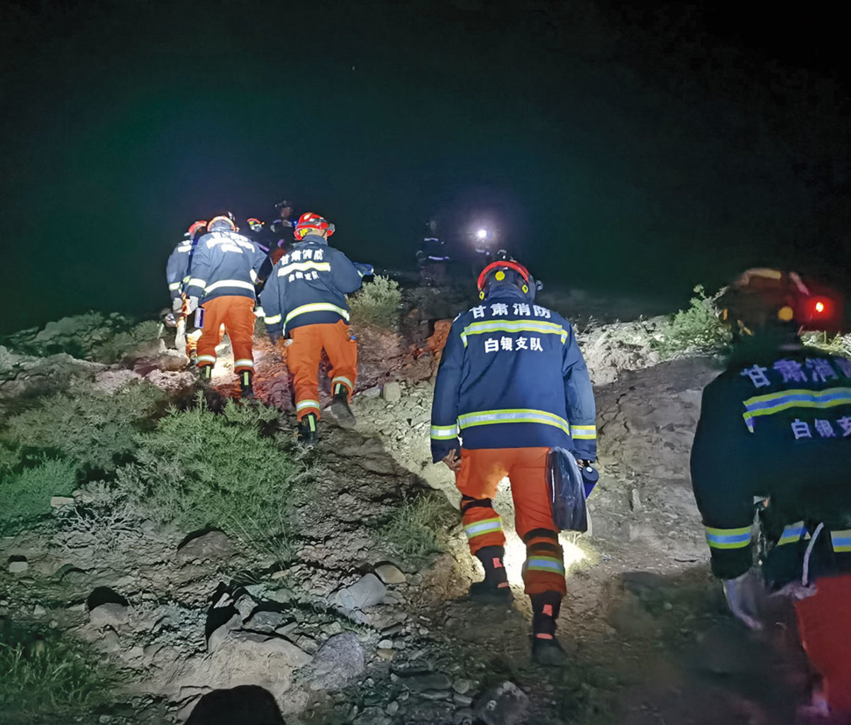 Rescue workers climbing hill in dark