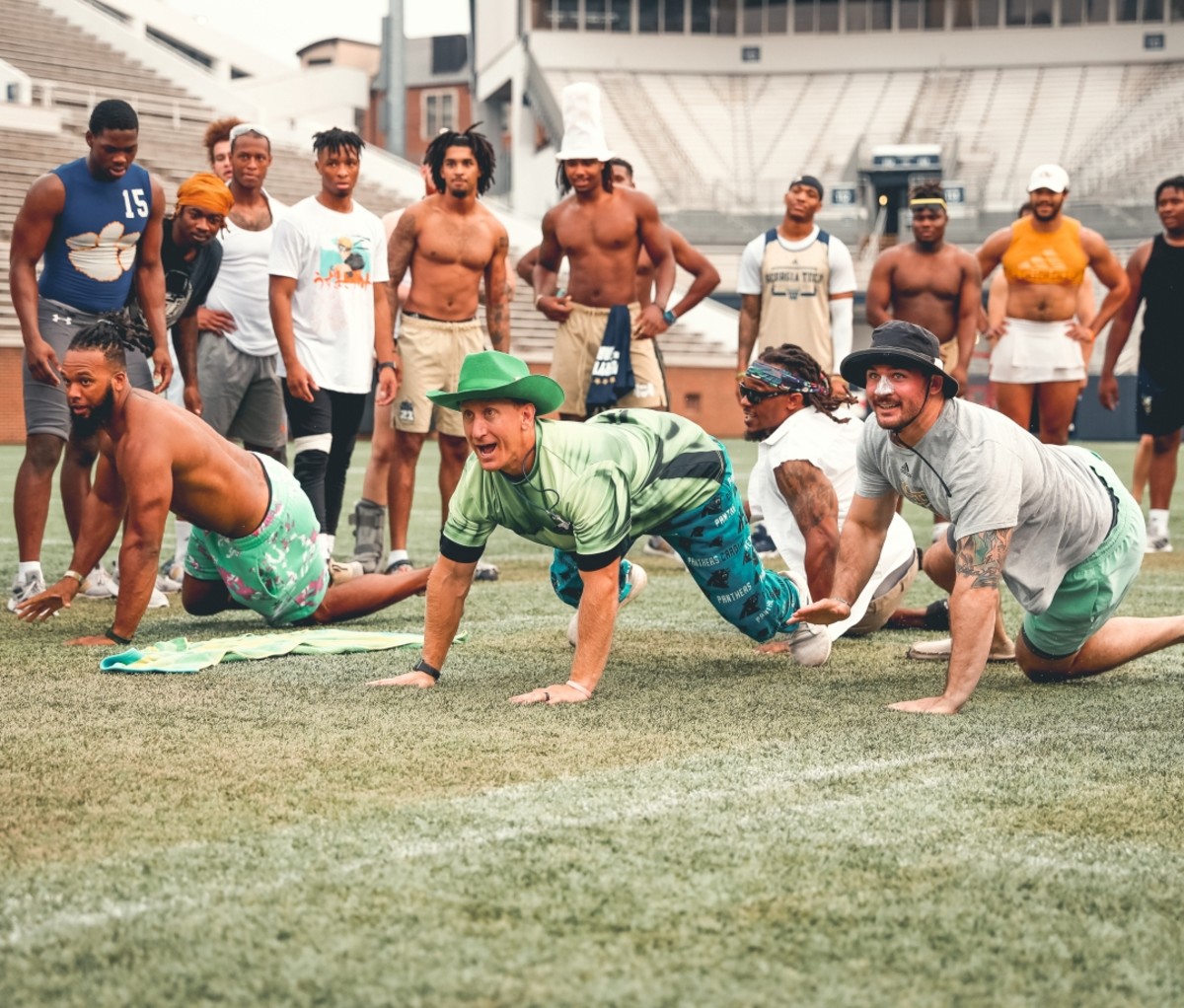 Lew Caralla dressed up in a green cowboy hat on a football field