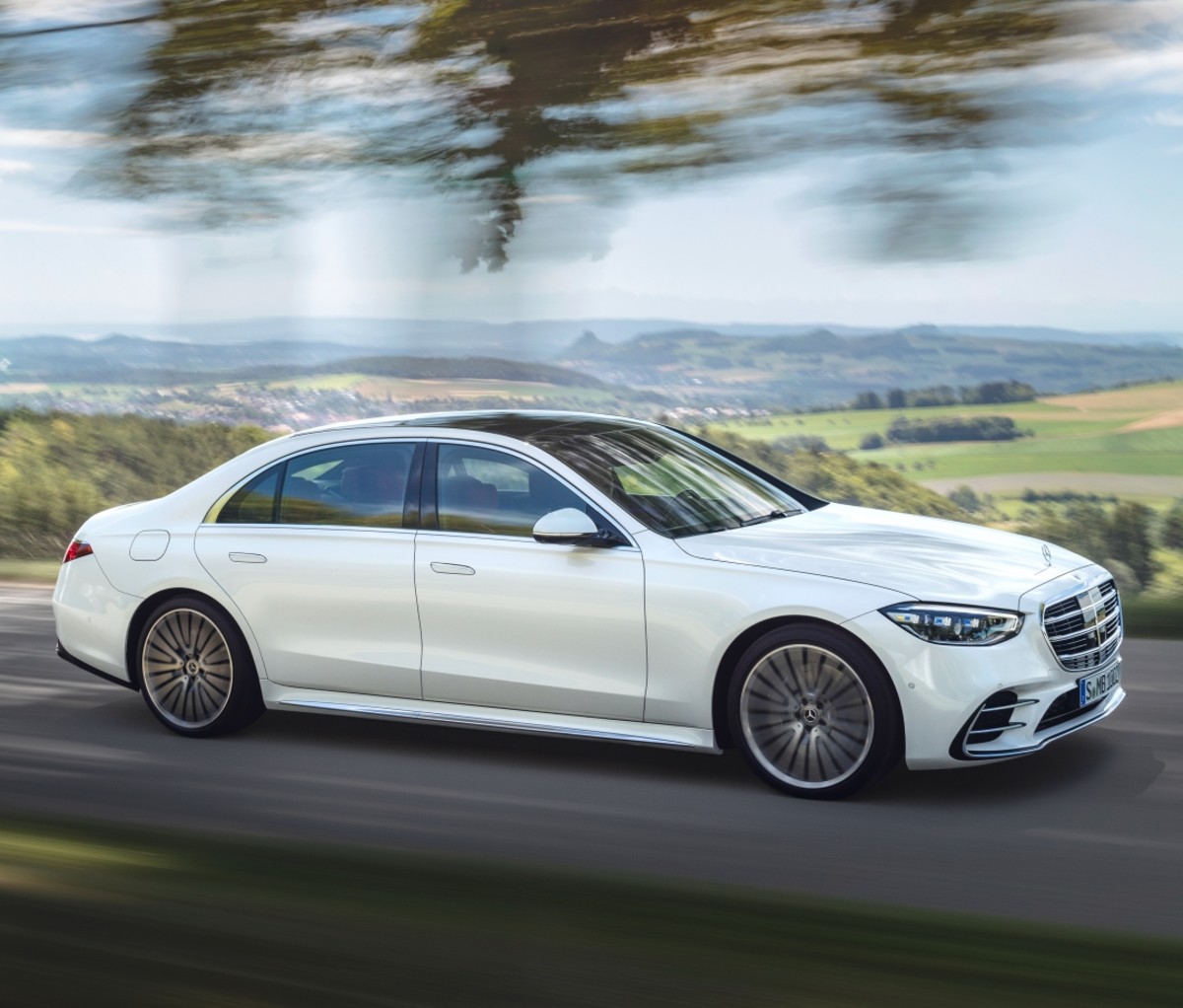 A white 2021 Mercedes-Benz S-Class sedan driving on a road