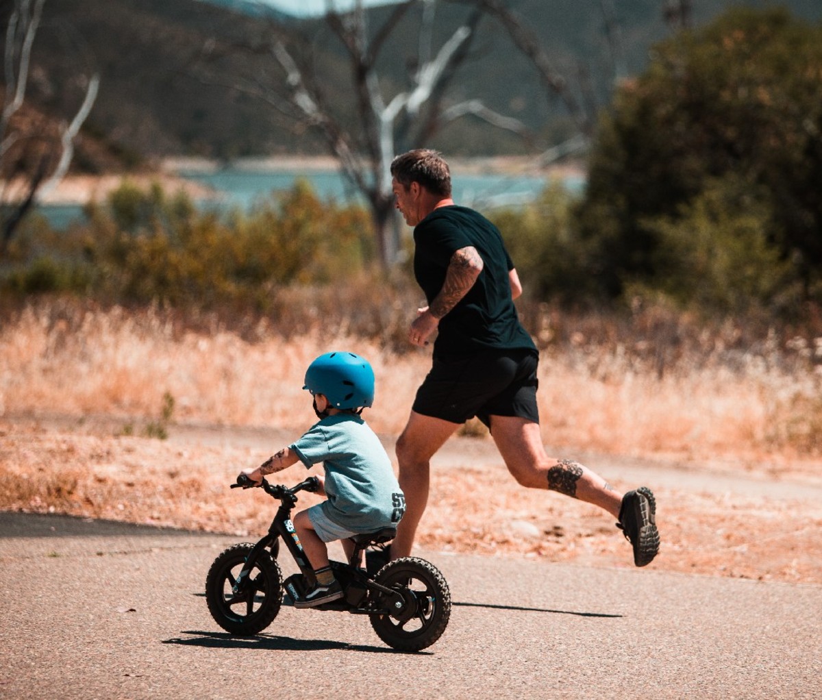 Man running alongside child on bike