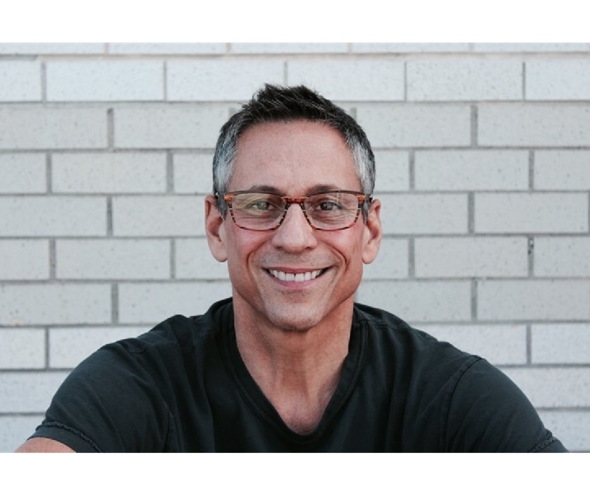 Man wearing prescription eyeglasses smiling at camera