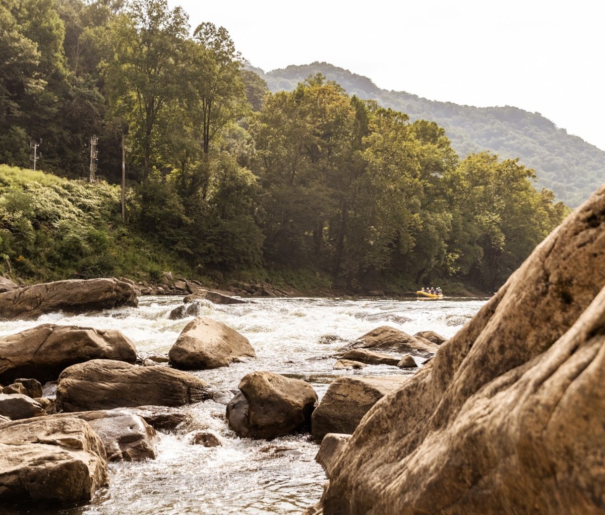 Rocks inset with paddlers off in distance on river