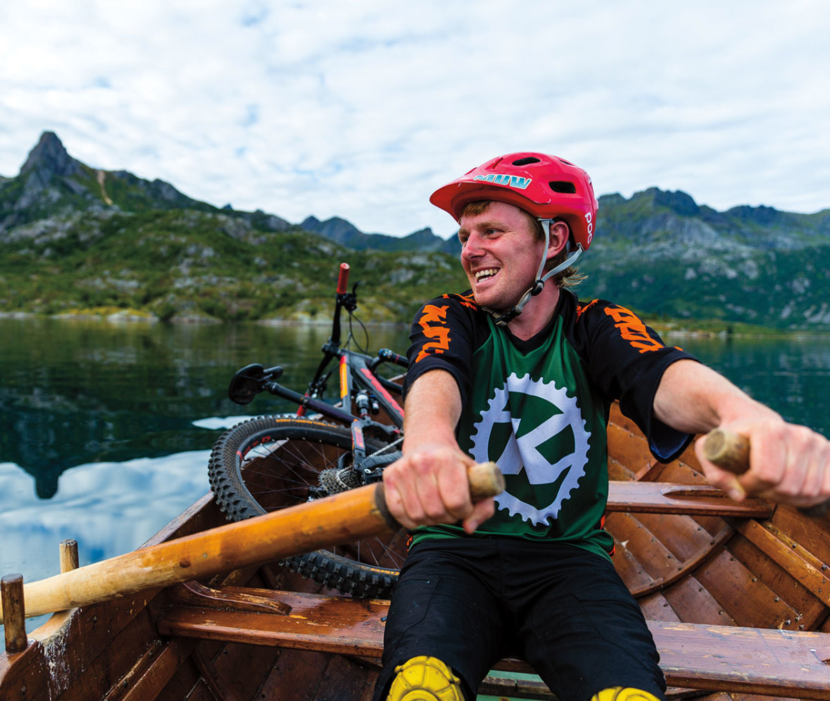 Mountain biker rowing bike across lake