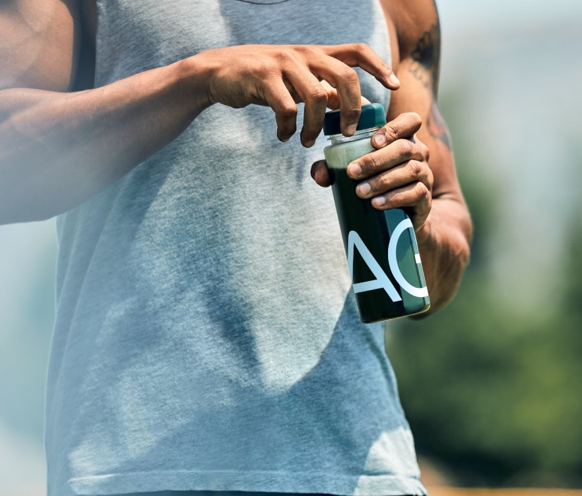 Man holding bottle of green juice