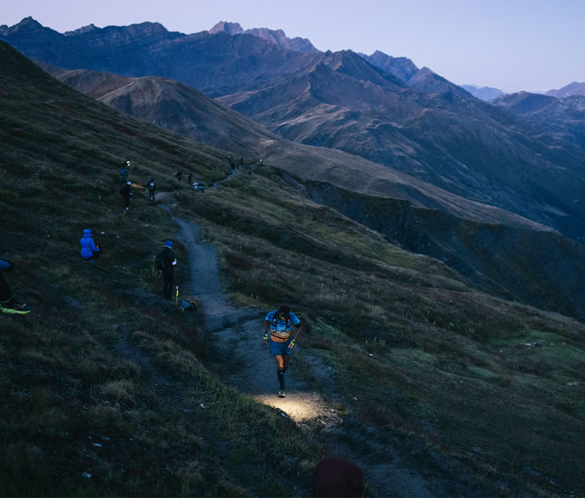 Man running through mountain trails at night