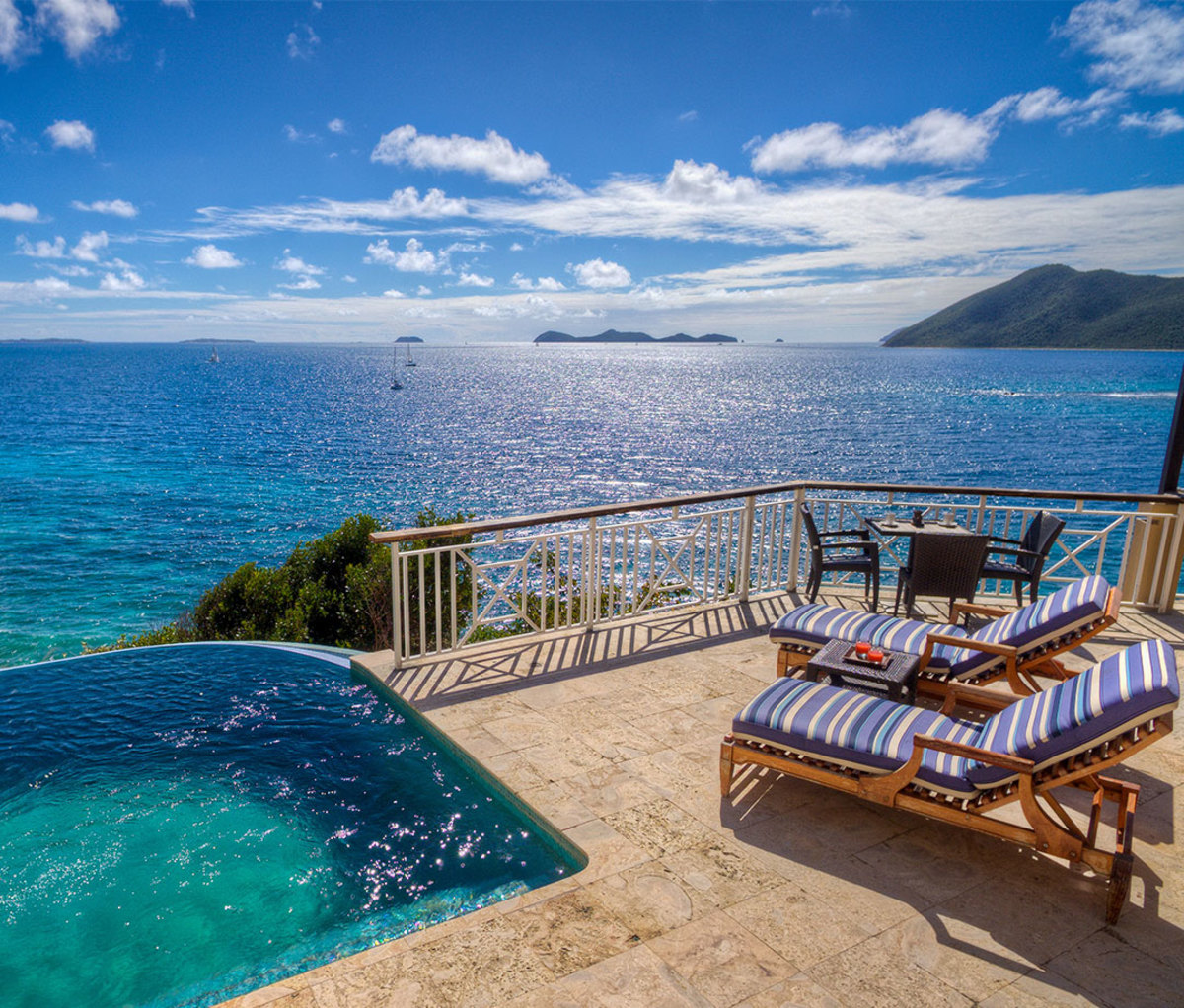 Resort patio with sun loungers and plunge pool overlooking water