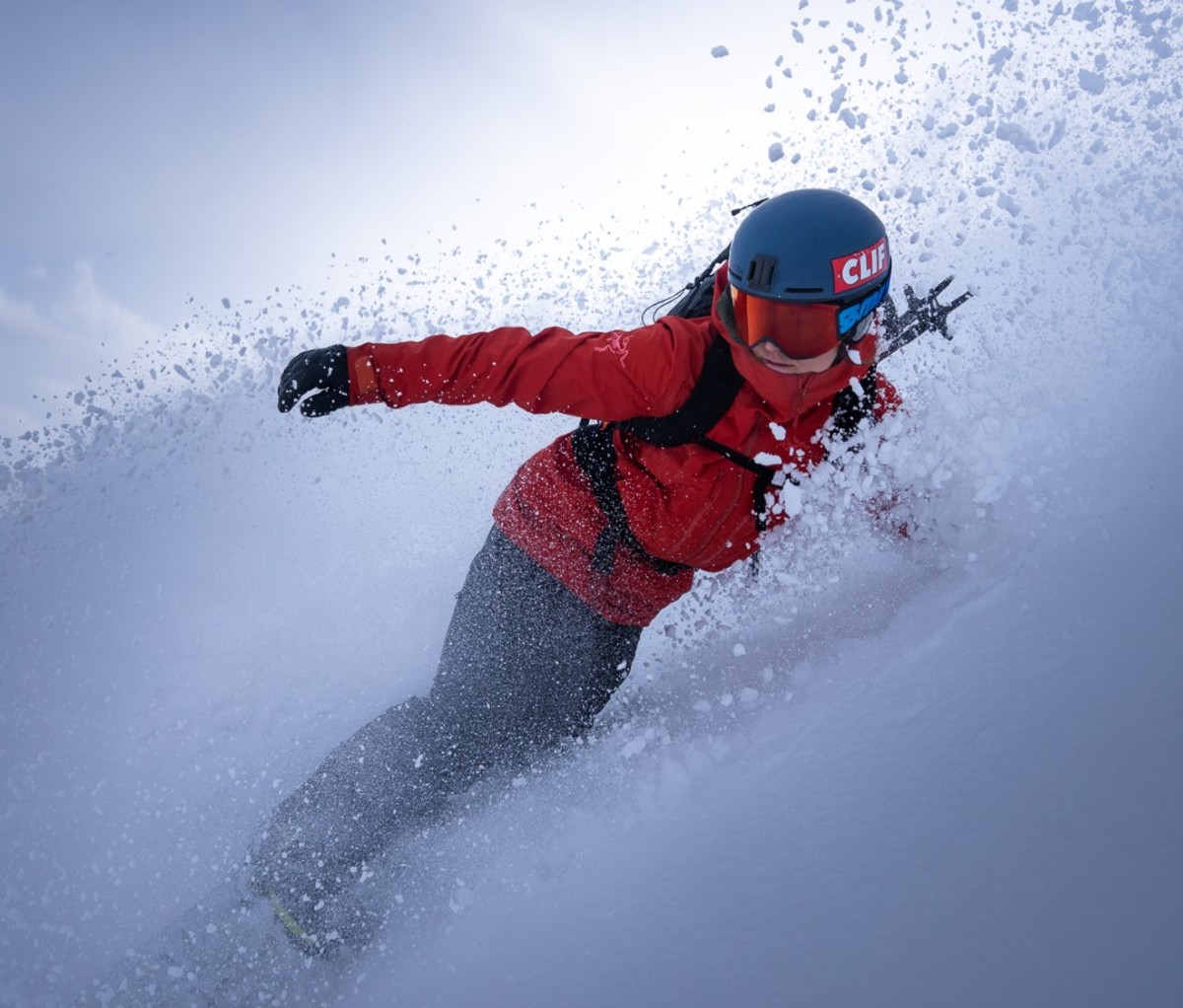 Action shot of female snowboarder going down mountain