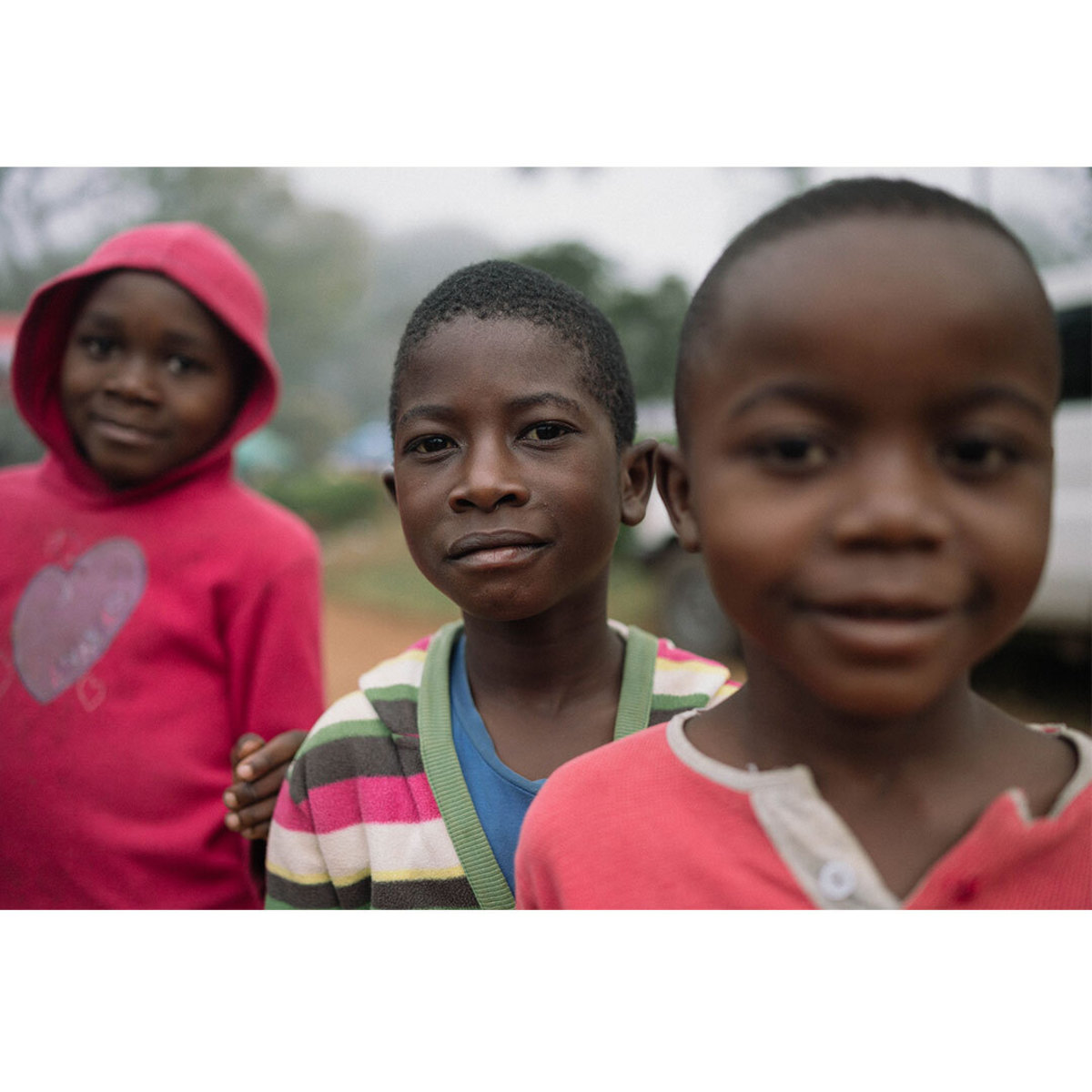 Three Malawian children looking directly into camera