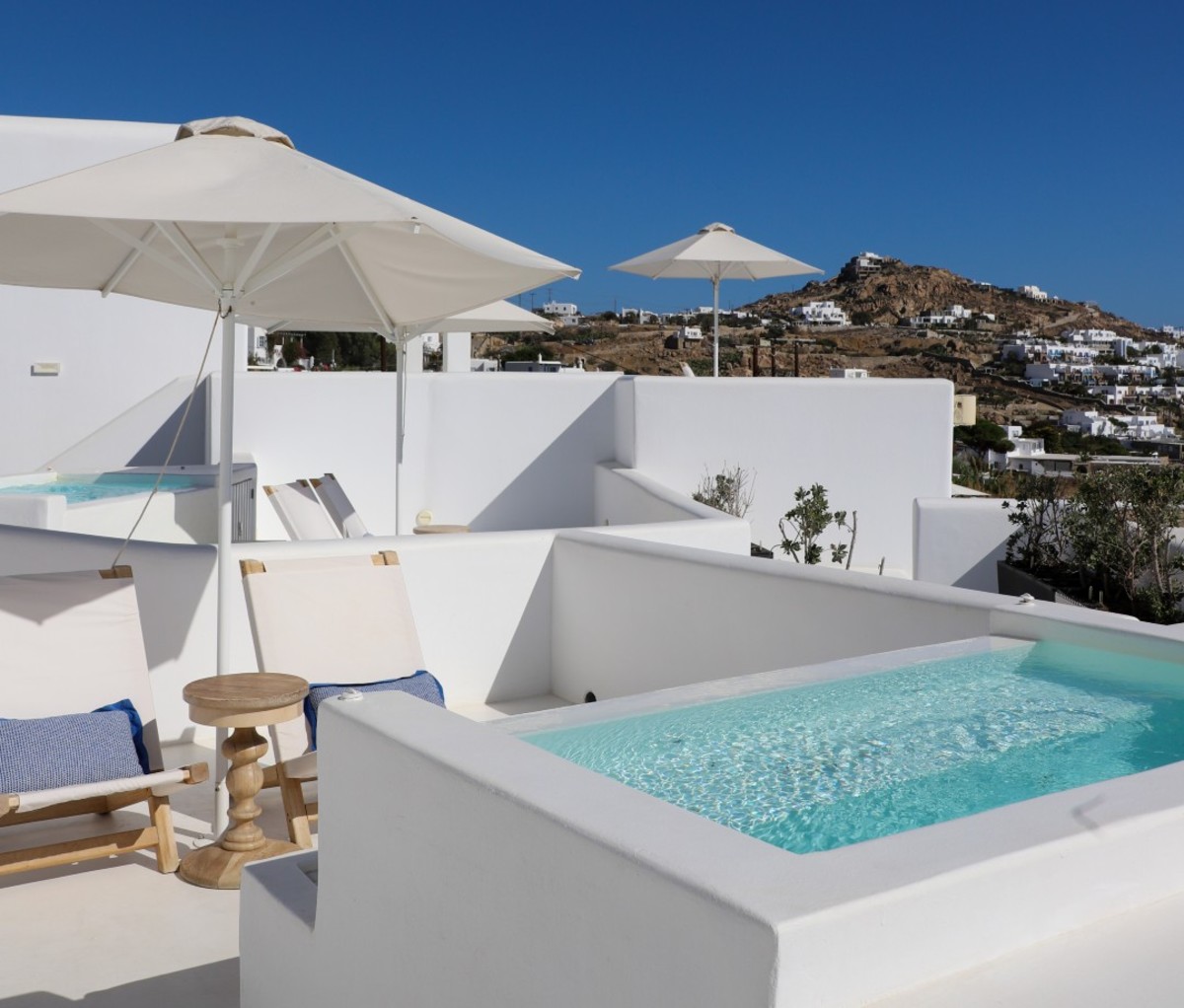 Luxury white-washed hotel suite with pool and island view