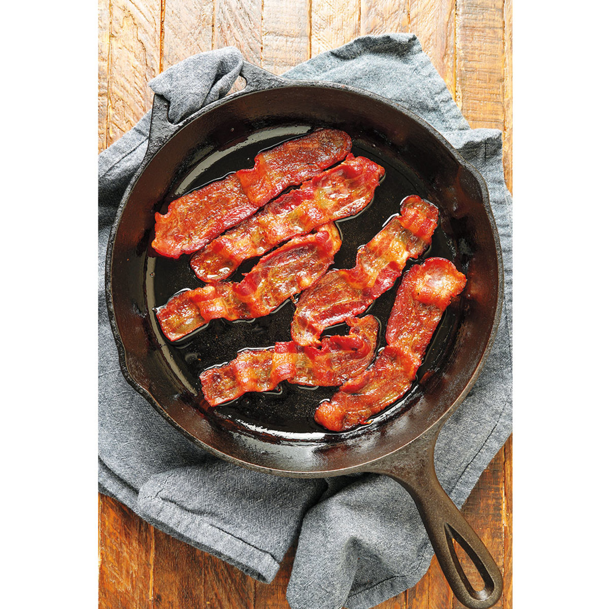 Bacon in cast iron skillet on towel