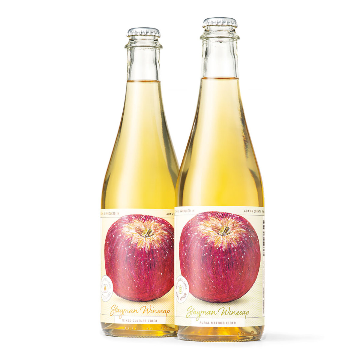 Two glass bottles of cider with apple on label