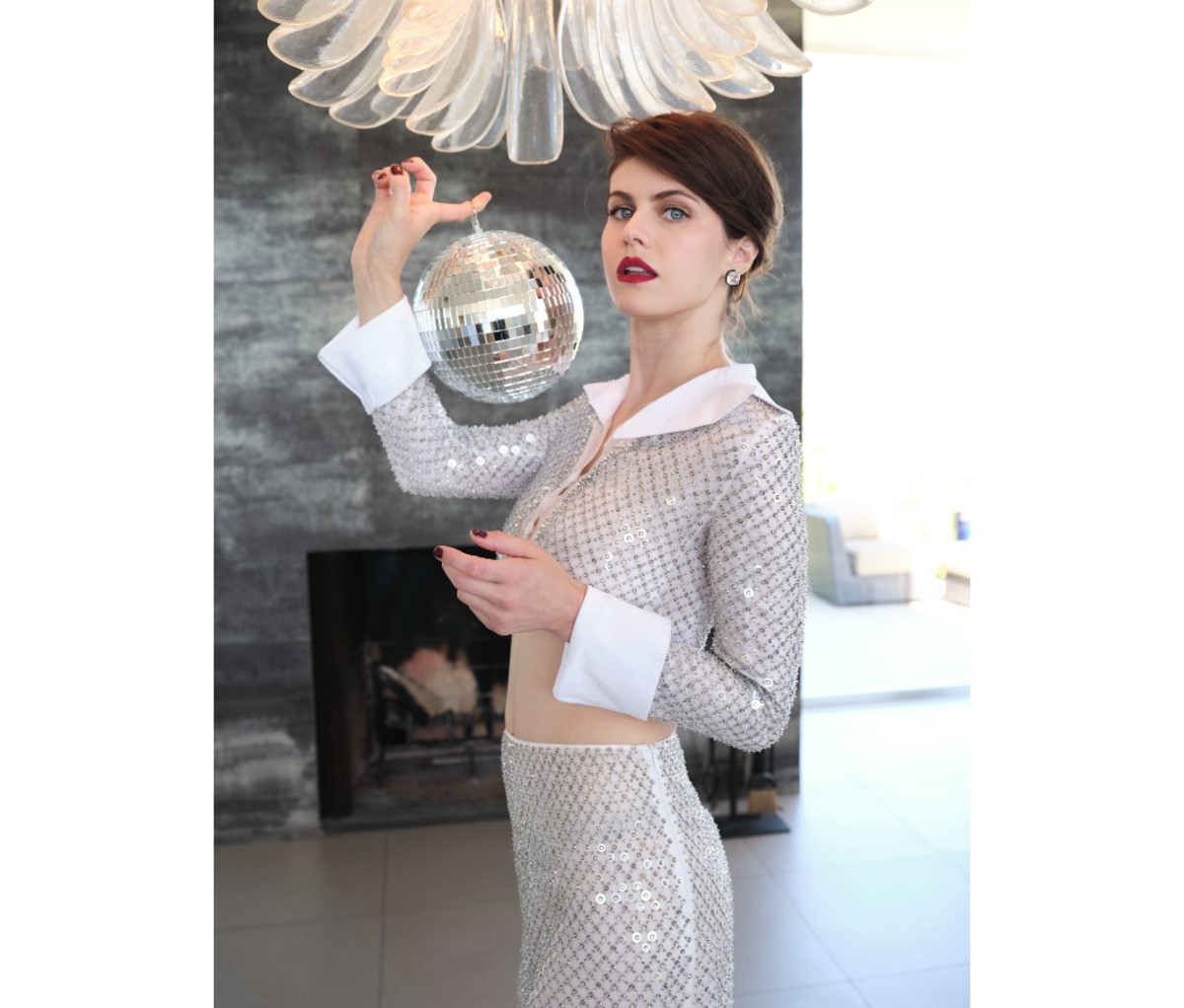 Alexandra Daddario wearing a sequined dress and holding a disco ball