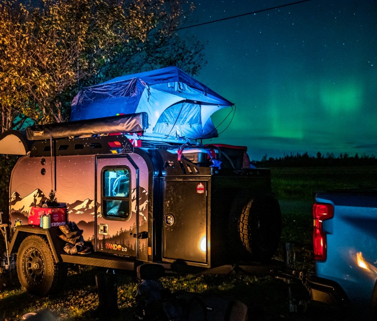 Teardrop camper trailer and rooftop tent at night under the Northern Lights. Trans-Labrador Highway