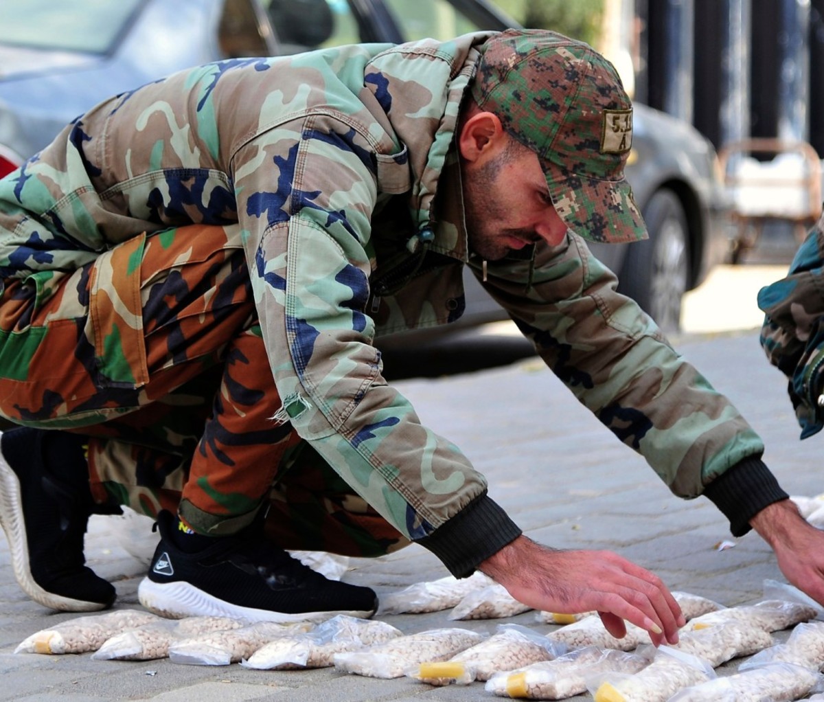 A Syrian soldier displays Captagon pills, in rural Damascus, Syria.
