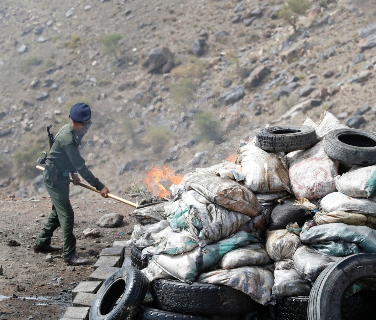 A Yemeni policeman incinerates sacks of seized narcotic drugs