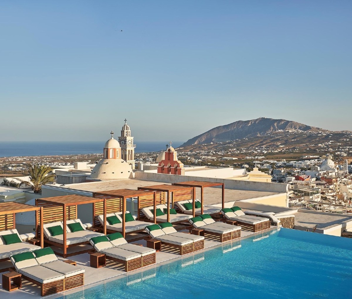 Rooftop pool with sun loungers overlooking Grecian island