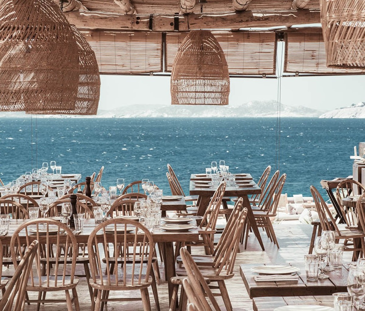 Seaside open-air restaurant with wood furniture