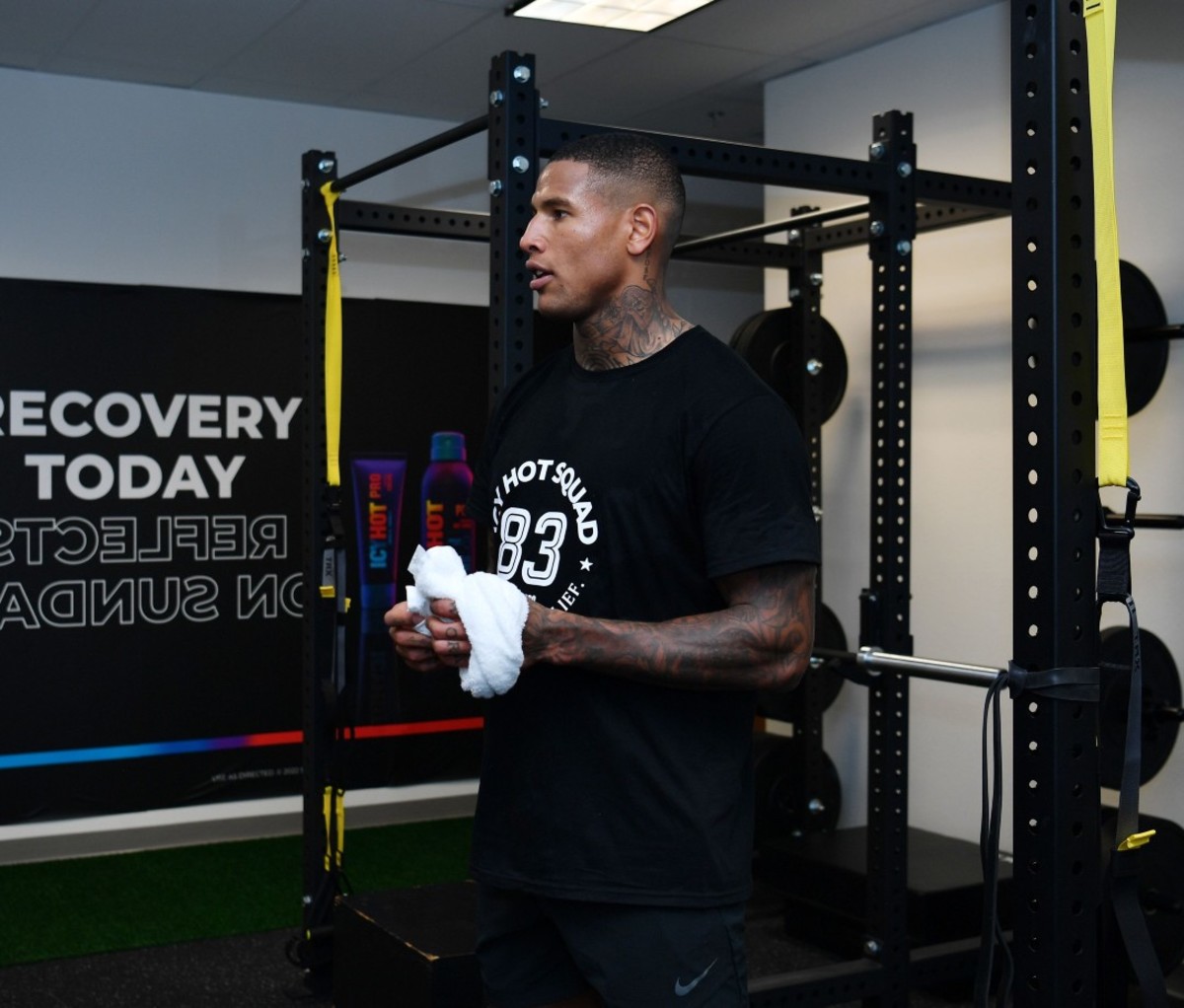 Athletic Black man standing in gym holding white towel