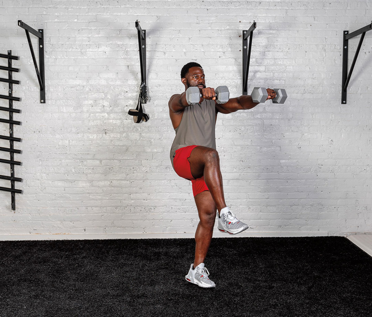 Black man wearing gray tank and red shorts doing Single-leg Front Raise