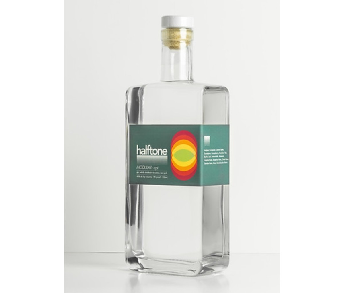 Rectangular, clear bottle of gin with a green label on an off-white background.