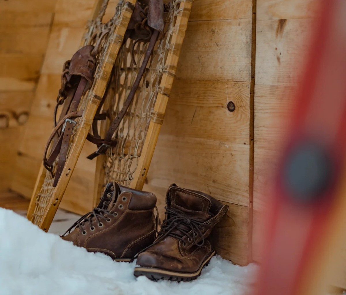 Snowshoes and boots outside in snow